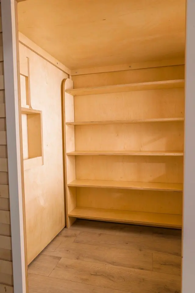 Interior view of wooden playhouse closet with built-in shelves