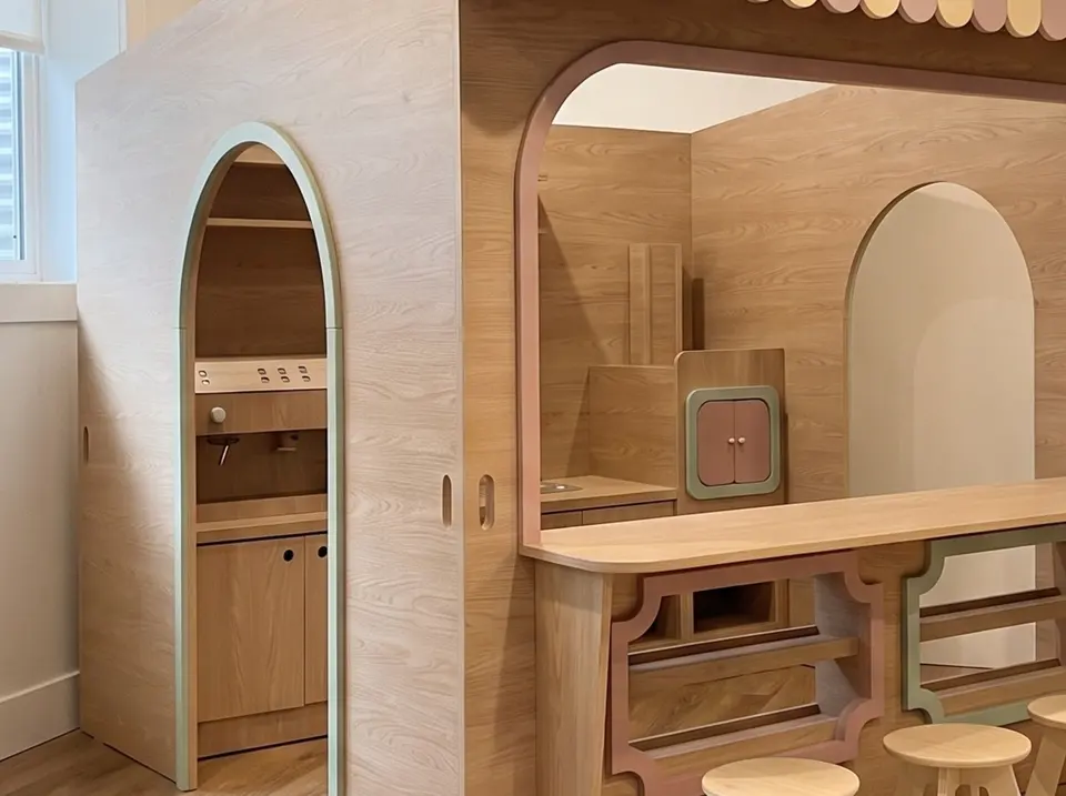 Installed wooden indoor cafe playhouse with arched doorway and counter in real room