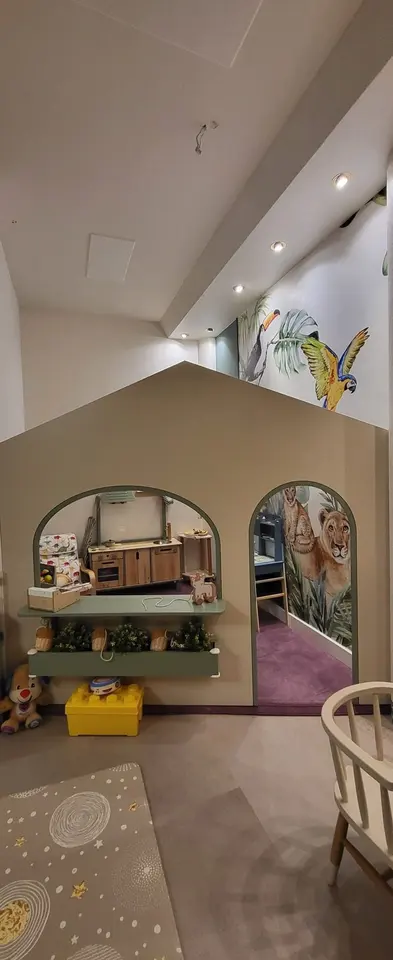 Indoor wooden playhouse structure with arched window and doorway