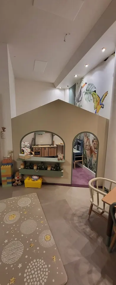 Custom built-in indoor playhouse facade with arched door and window