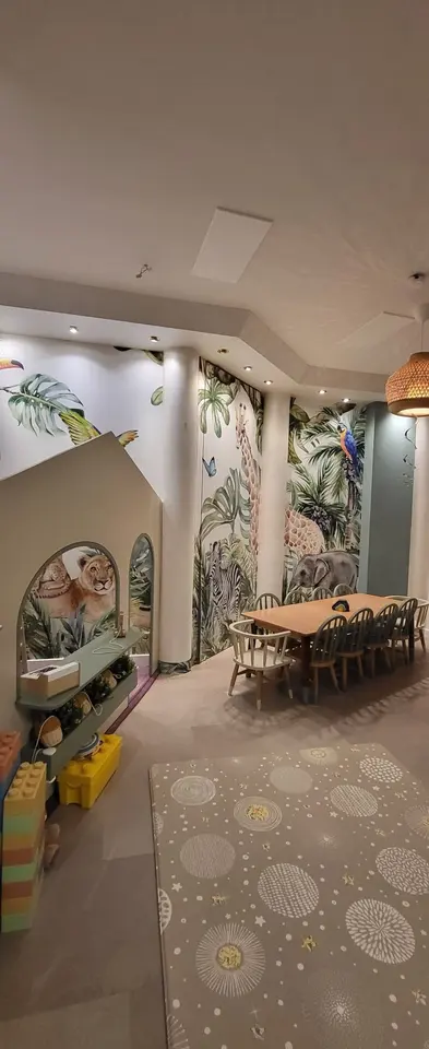 Indoor playhouse structure and dining table in a jungle themed playroom