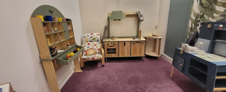 Wooden play kitchen and grocery stand set in a children playroom