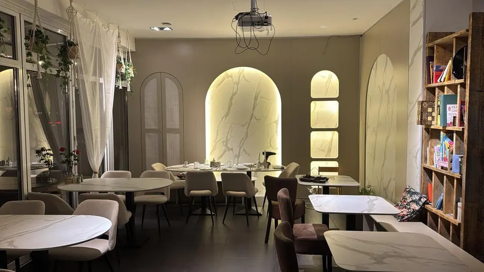 Dining tables and illuminated arched wall niches in modern cafe interior
