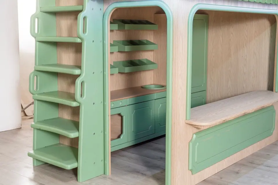 Green play kitchen and market counter under wooden playhouse bunk structure