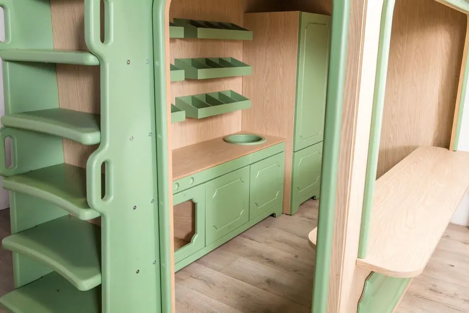 Side ladder and play kitchen interior of light wood playhouse