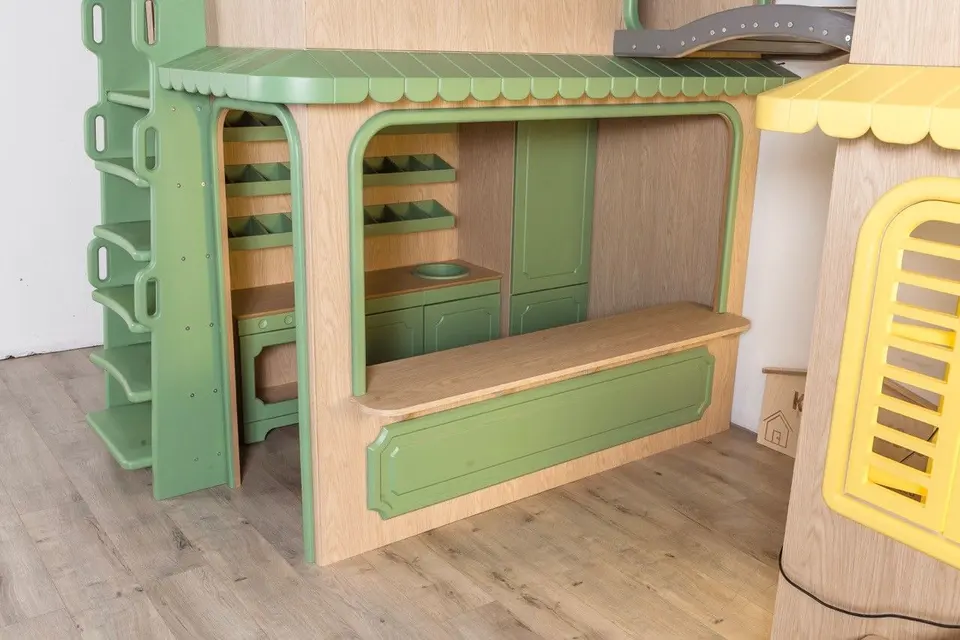 Front serving counter and play shop stall under green trimmed wooden canopy