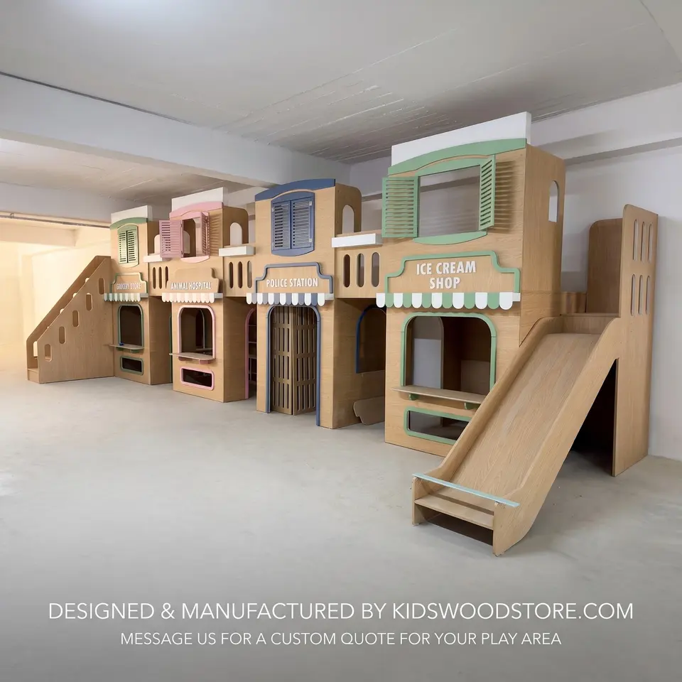 Multi level wooden play town setup with wooden slide in large open area