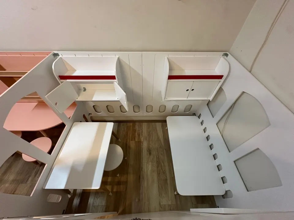 Top view inside a doctor themed wooden playhouse with desk and bench