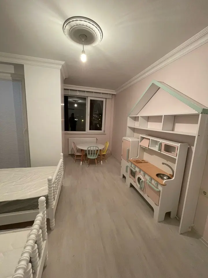 Children room with spindle bed, table set, and play kitchen bookcase unit