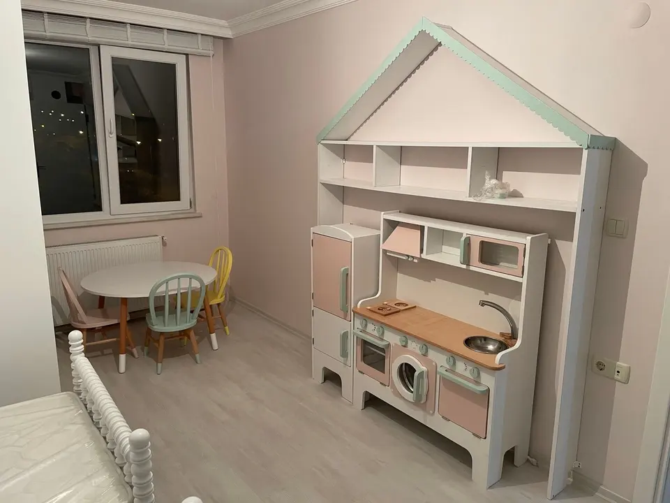 Kids play kitchen set under house-shaped shelving unit in bedroom