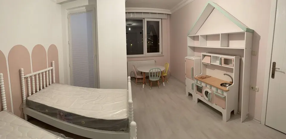 White spindle bed and play kitchen playhouse unit in a child's bedroom