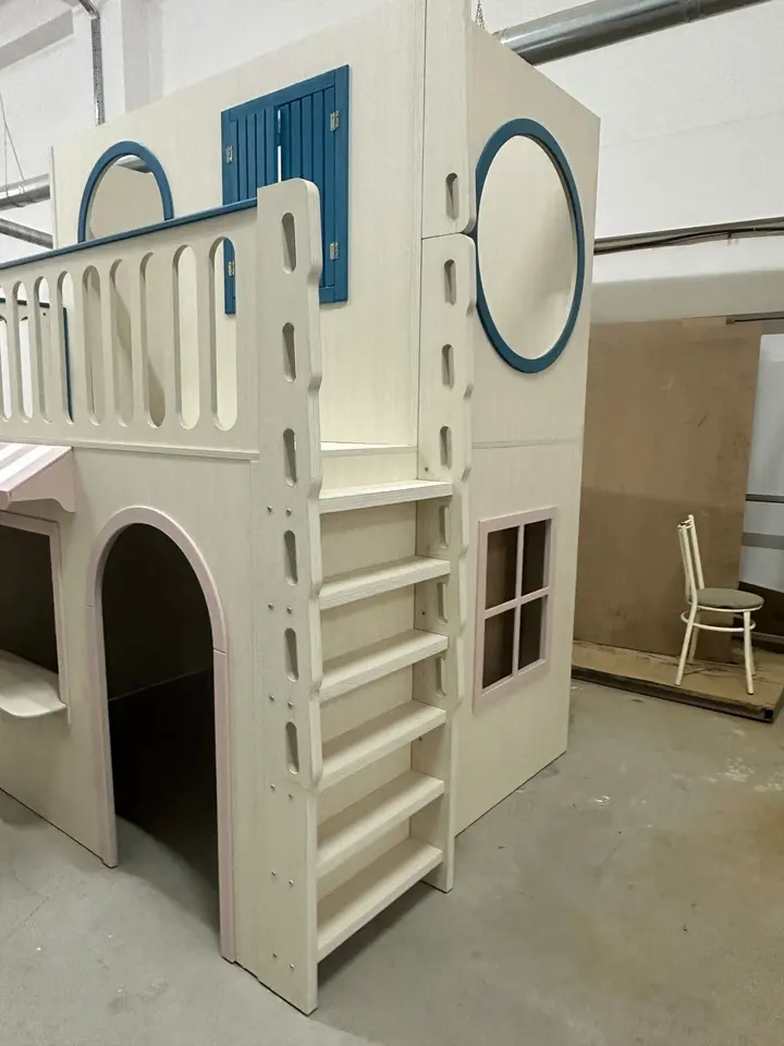 Two-story indoor wooden playhouse structure with ladder and blue accents