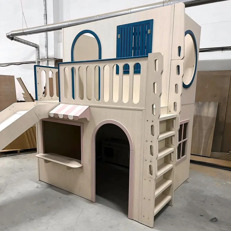 Completed coastal style wooden playhouse bunk bed with slide in workshop