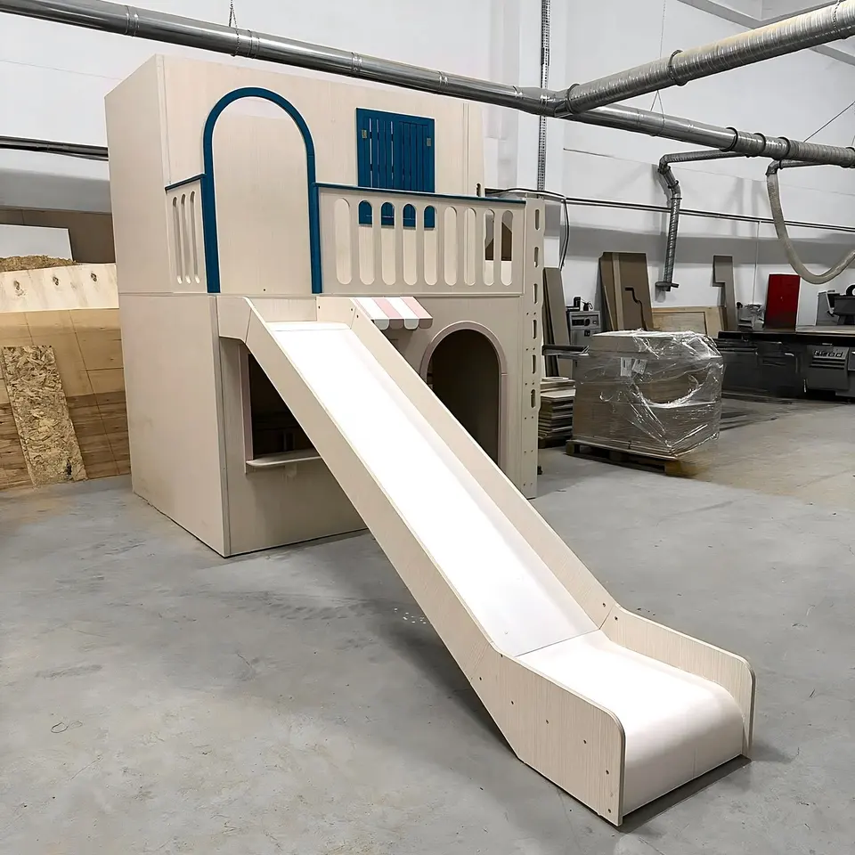 Front view of completed wooden playhouse with extended slide in workshop