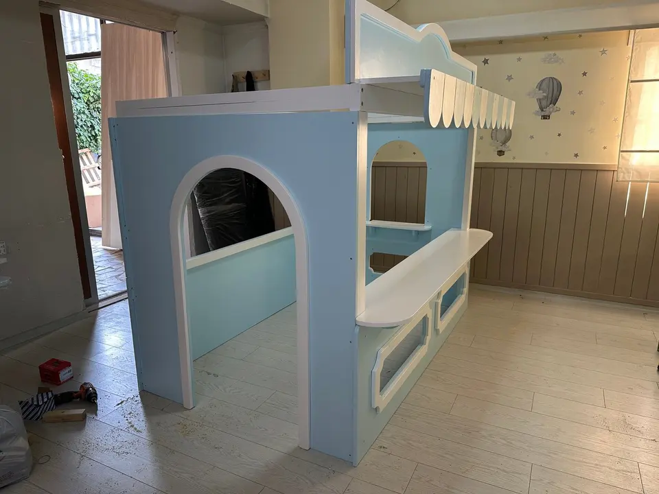 Light blue wooden play market stall during installation in a playroom