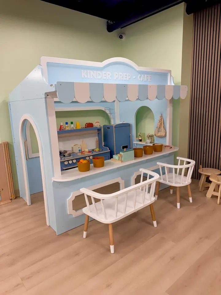 Pastel blue playhouse cafe with pretend kitchen and white bench seating