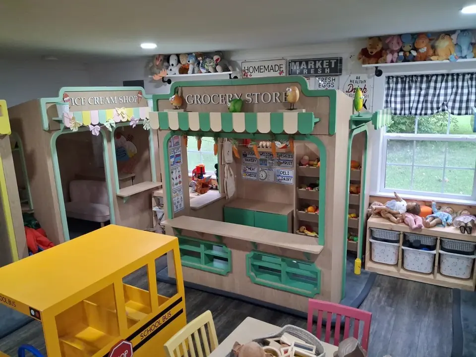 Indoor wooden grocery store playhouse set in a playroom