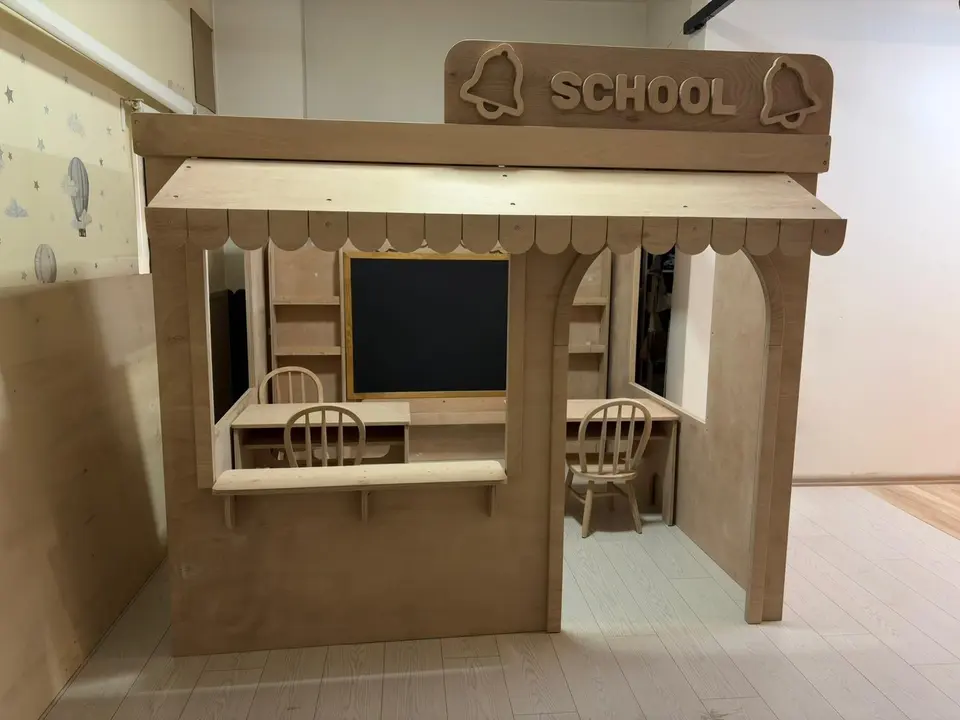 Front exterior of natural wood school playhouse with awning, counter, and arched doorway