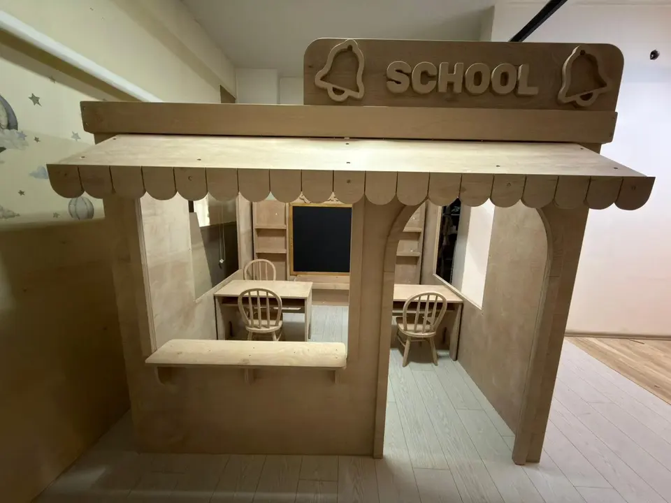 Natural wood school themed indoor playhouse with awning and study desks