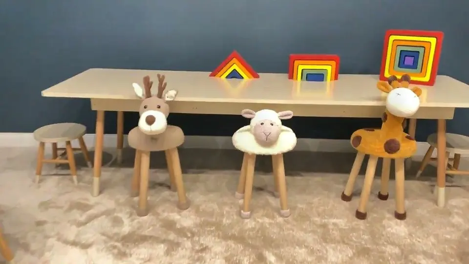 Kids craft table with plush deer, sheep, and giraffe wooden stools