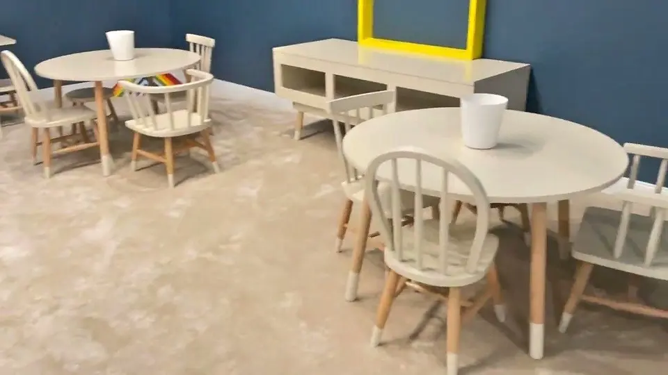 Children wooden tables, matching chairs, and low storage console in playroom