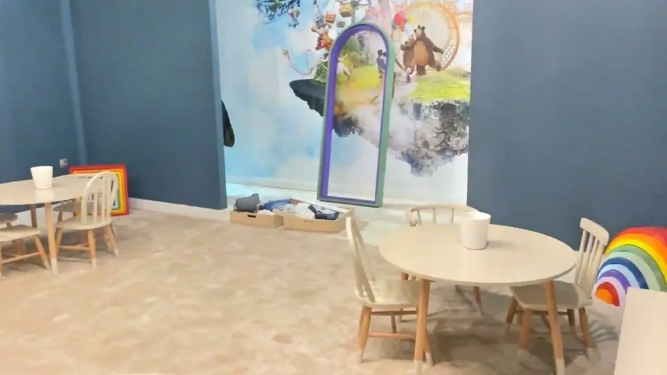 Round wooden kids table and chairs in an indoor playroom setting