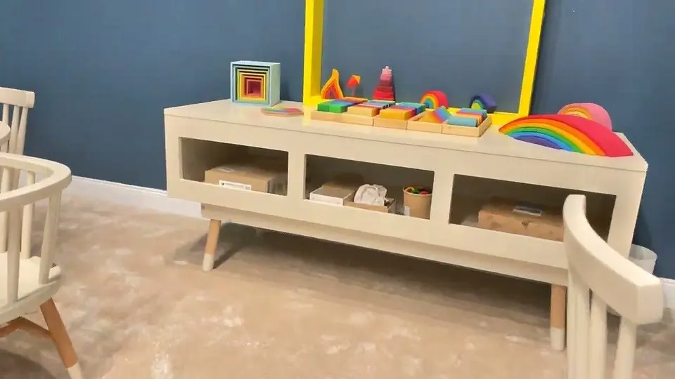 White wooden storage console table with open shelving and toy display