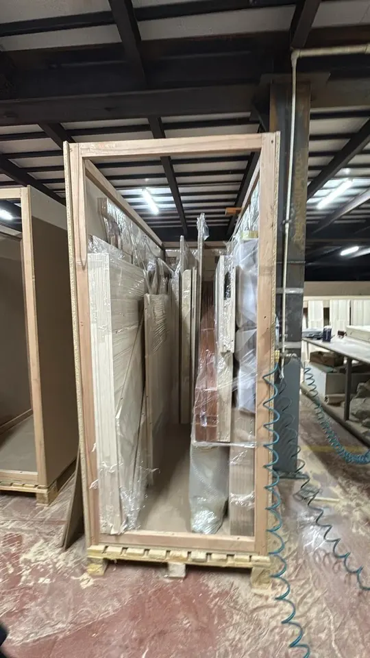 Tall wooden crate with wrapped furniture panels prepared for shipping
