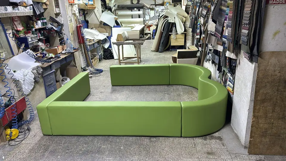 Green vinyl padded soft play enclosure benches in workshop