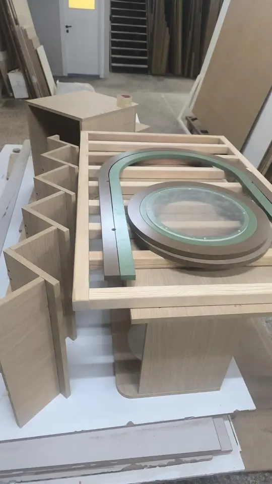 Disassembled wooden components and curved trim pieces in the workshop