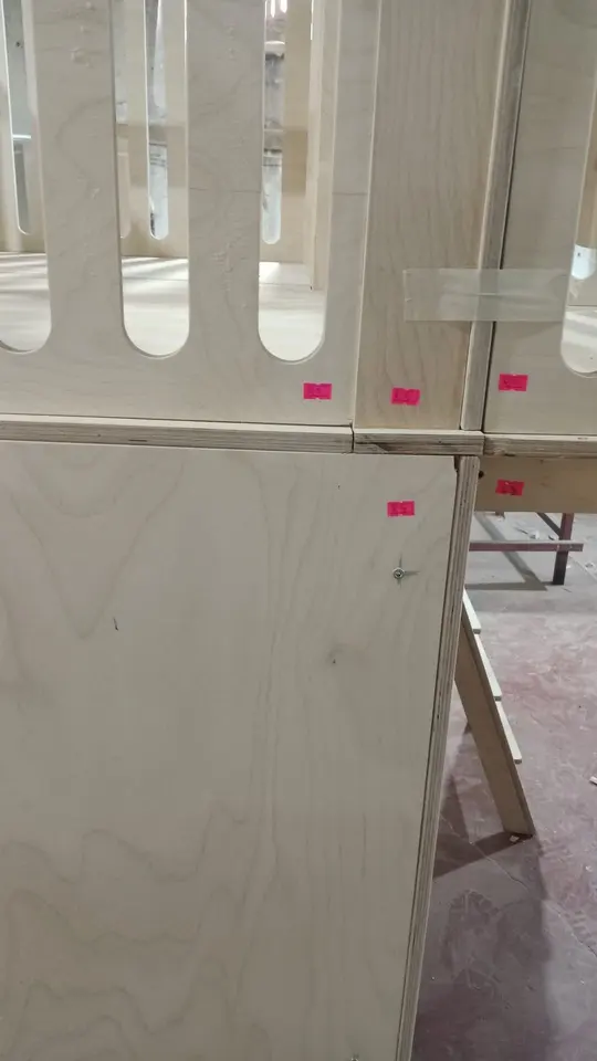 Unfinished birch plywood play structure assembly with pink alignment stickers