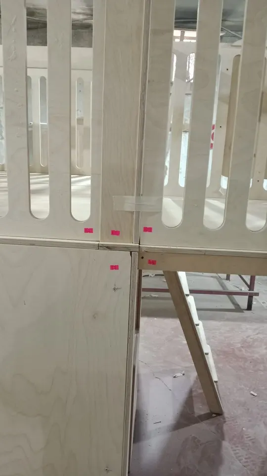 Raw plywood play loft and railing assembly in workshop