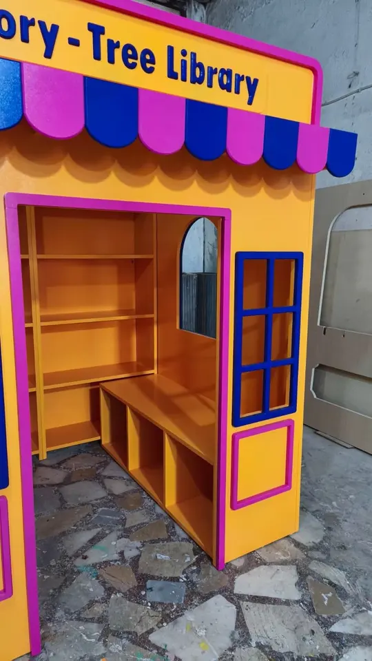 Finished yellow and pink wooden library playhouse assembled in workshop
