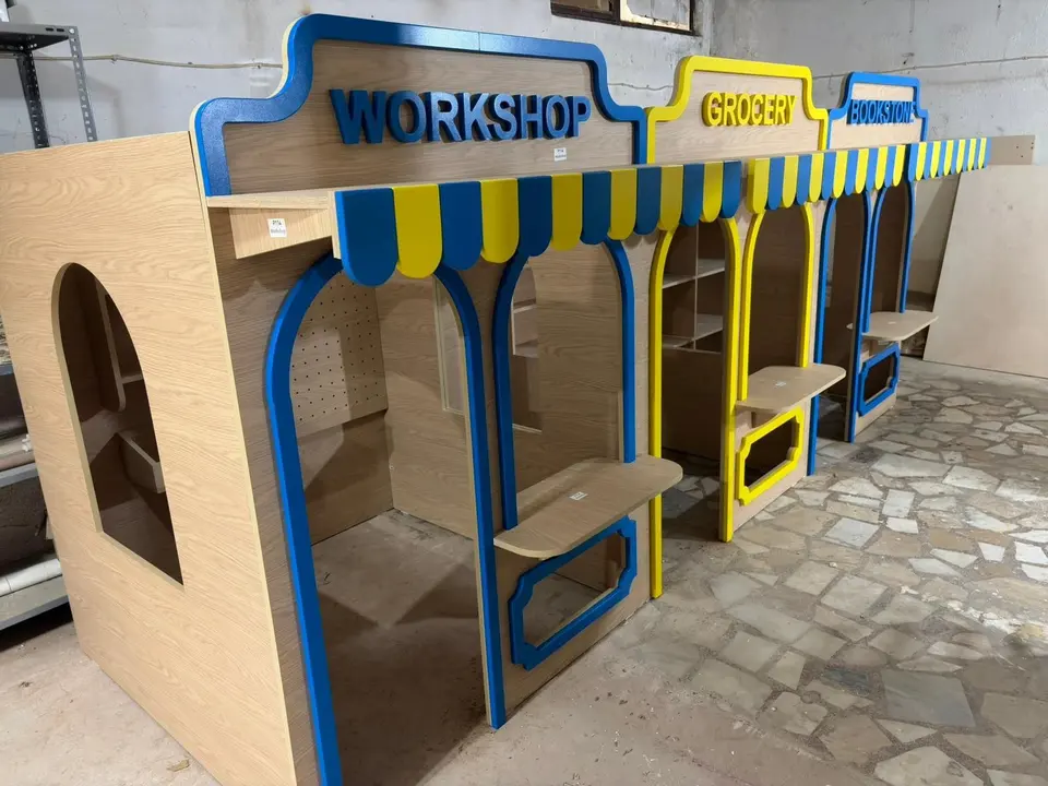 Angle view of connected wooden role play stalls in workshop