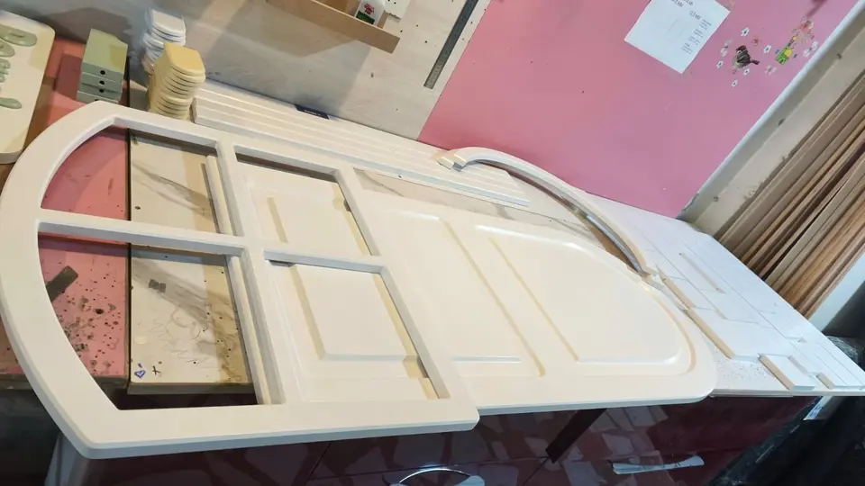 Painted white wooden window frames on a workshop table
