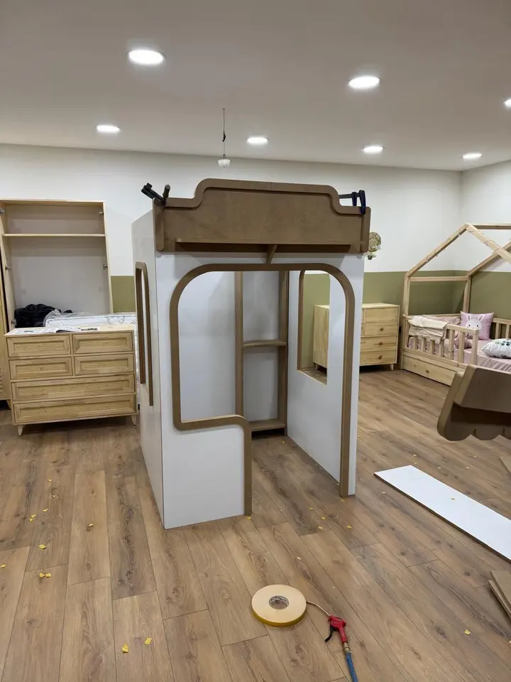 Playhouse frame under assembly with clamps and tape on the floor