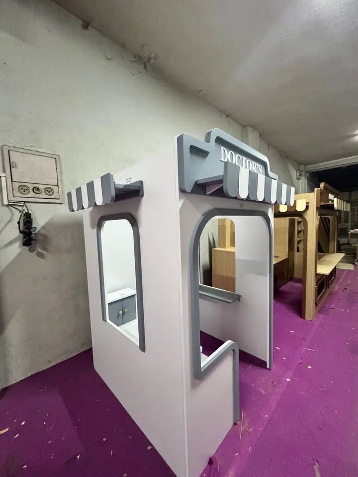 Grey and white wooden doctor playhouse kiosk inside workshop