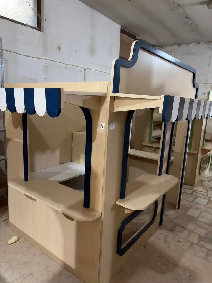 Corner view of wooden playhouse market stalls in workshop